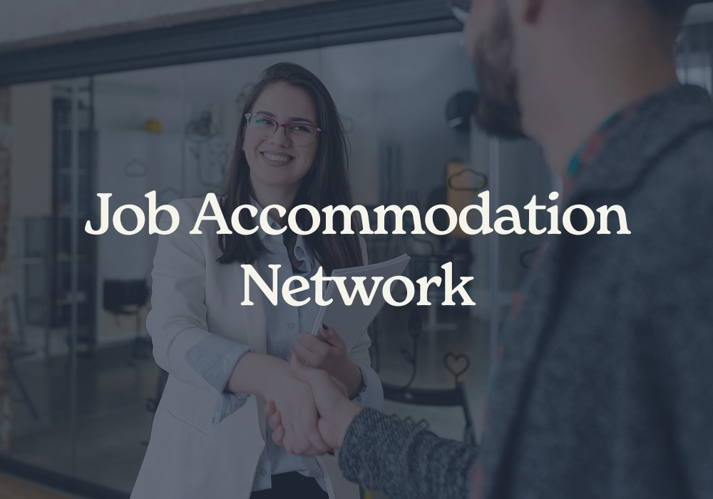 Two professionals shaking hands during a workplace accommodation discussion in an office setting