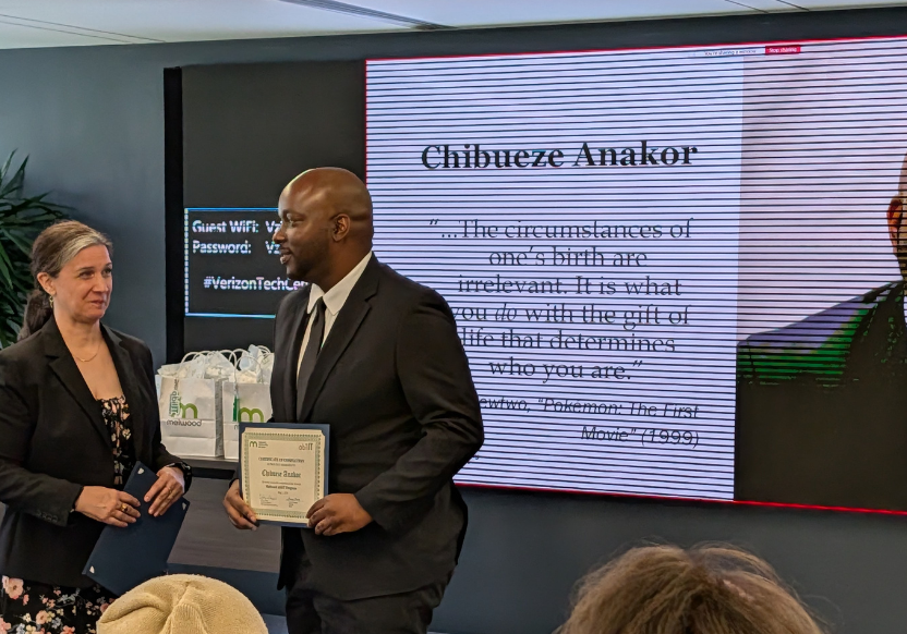 A man in a dark suit accepting a certificate, while on the screen behind them are the words "Chibueze Anakor" and a quote that is not legible